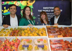 Andres Ocampo, Melissa Hartmann de Barros, Cecilia Doyle and Jack Jackson with HLB Specialties are posing with a colorful display of dragon fruit and rambutan.